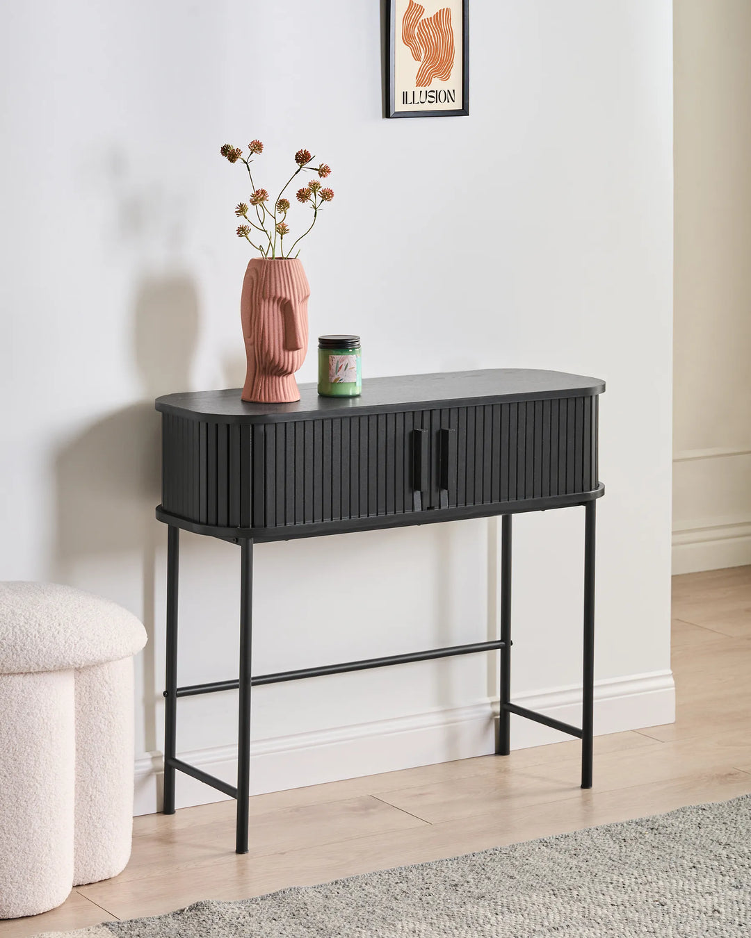 Black console table with decorative items against a white wall