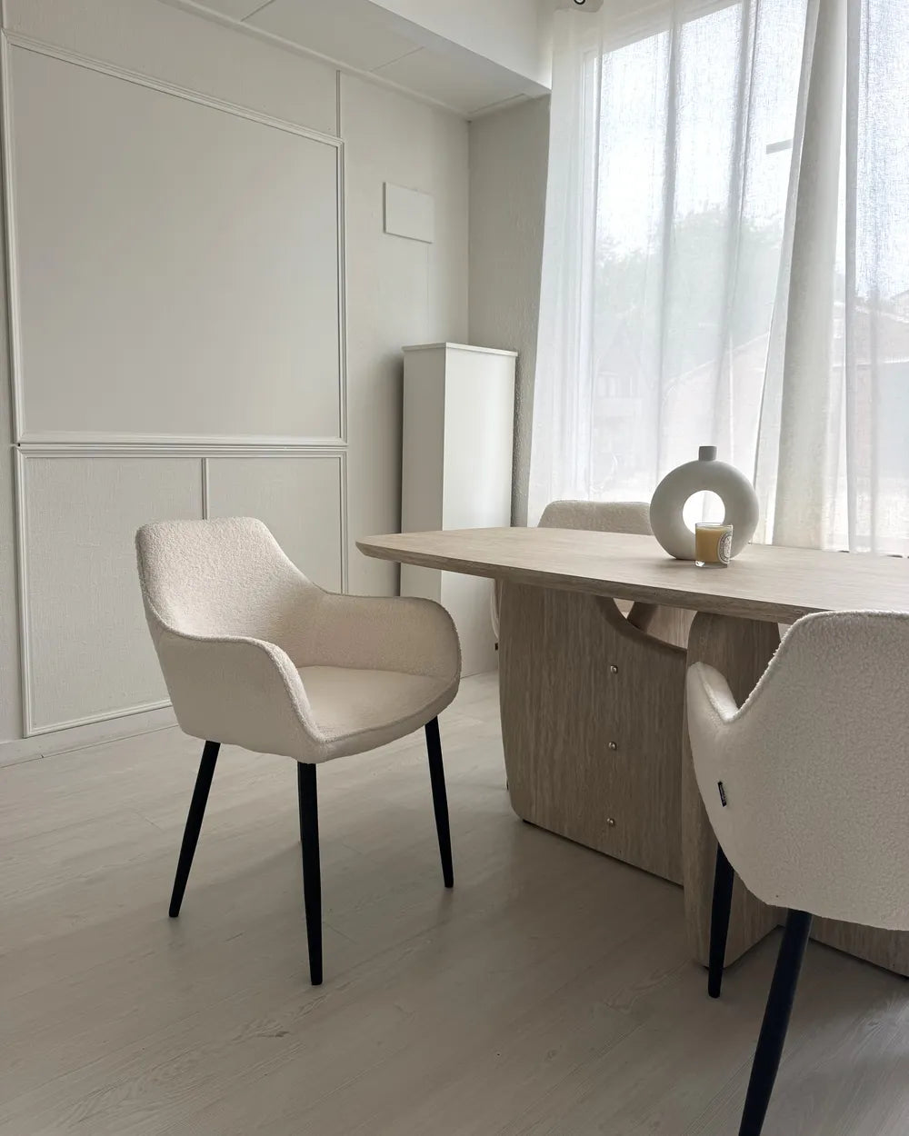 White boucle dining chairs with textured upholstery