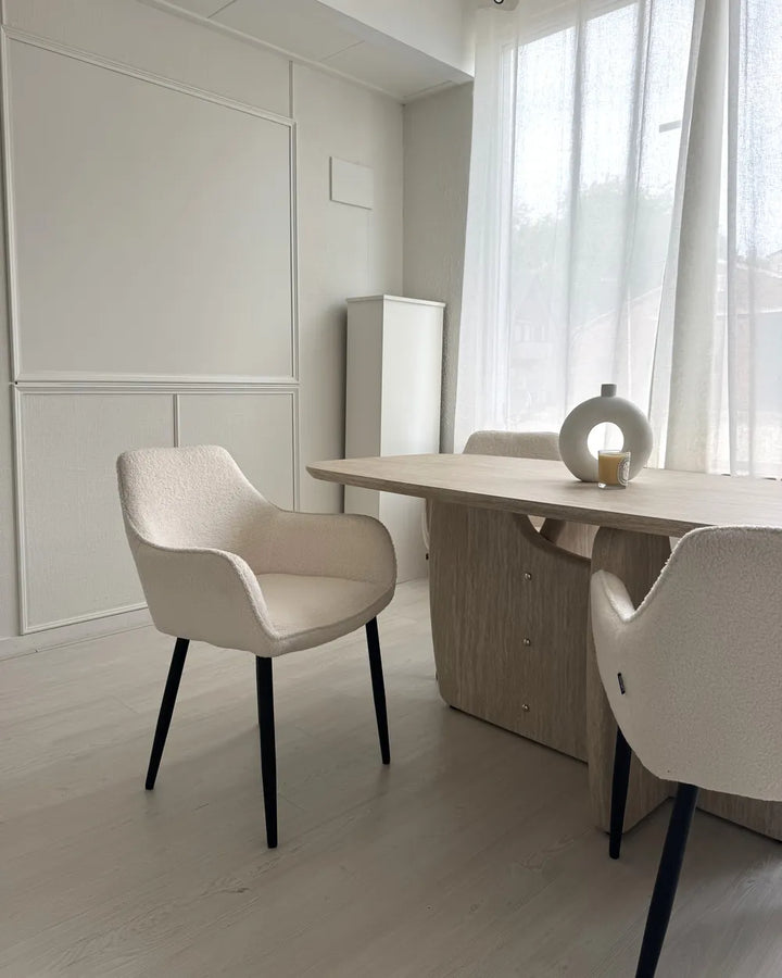White boucle dining chairs with textured upholstery