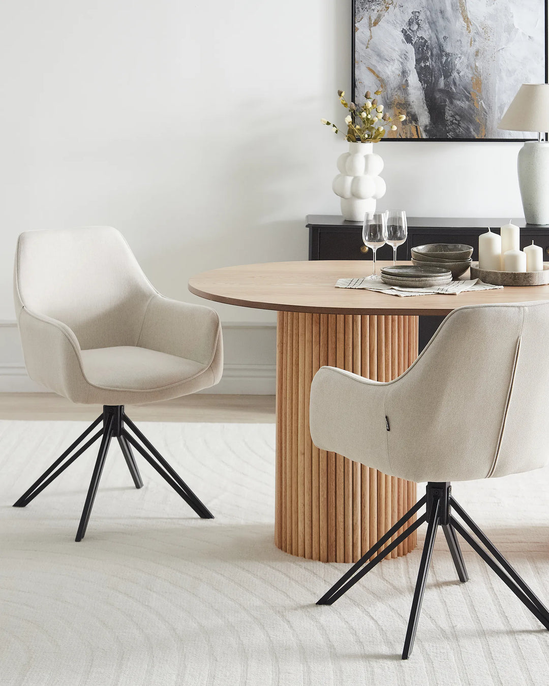 Modern dining room with round wooden table and beige chairs.