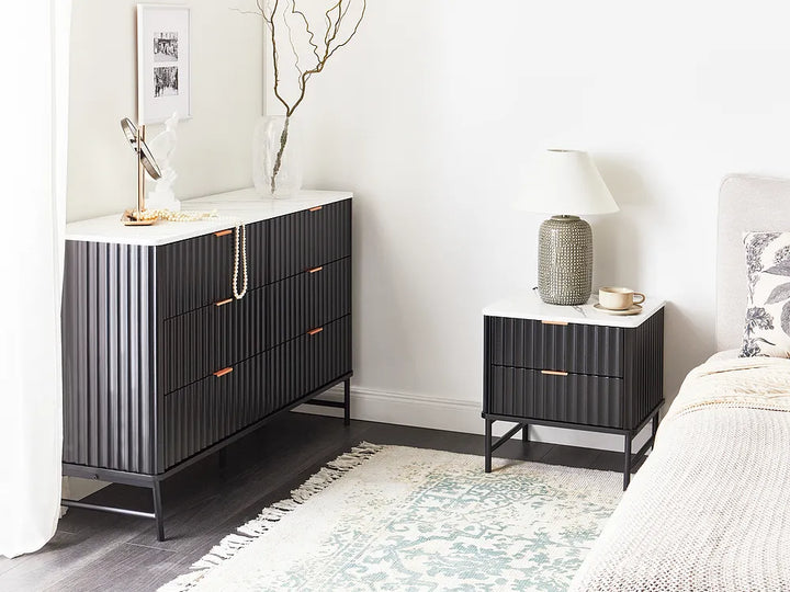 Black dresser and nightstand with decorative items in a bedroom setting