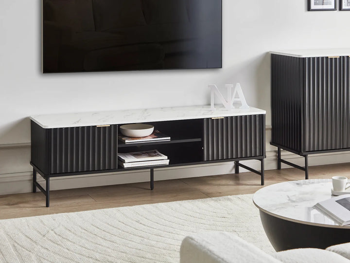 A modern living room setup featuring a black media console with a white marble top.