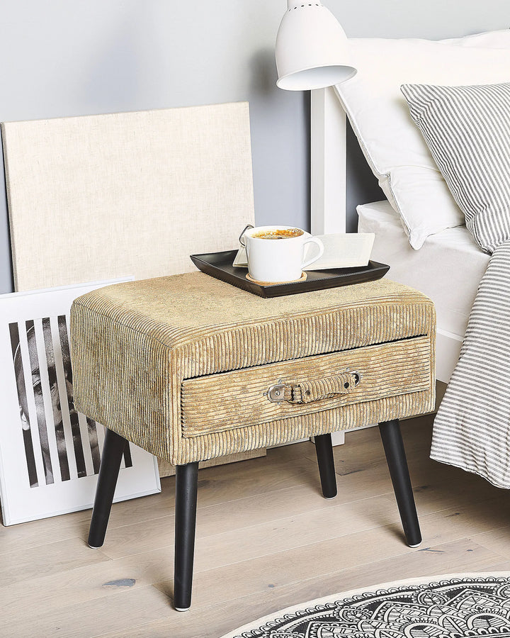 Beige textured nightstand with a drawer next to a bed with striped bedding.