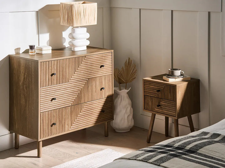 Wooden dresser with chevron pattern and matching nightstand in a bedroom setting.