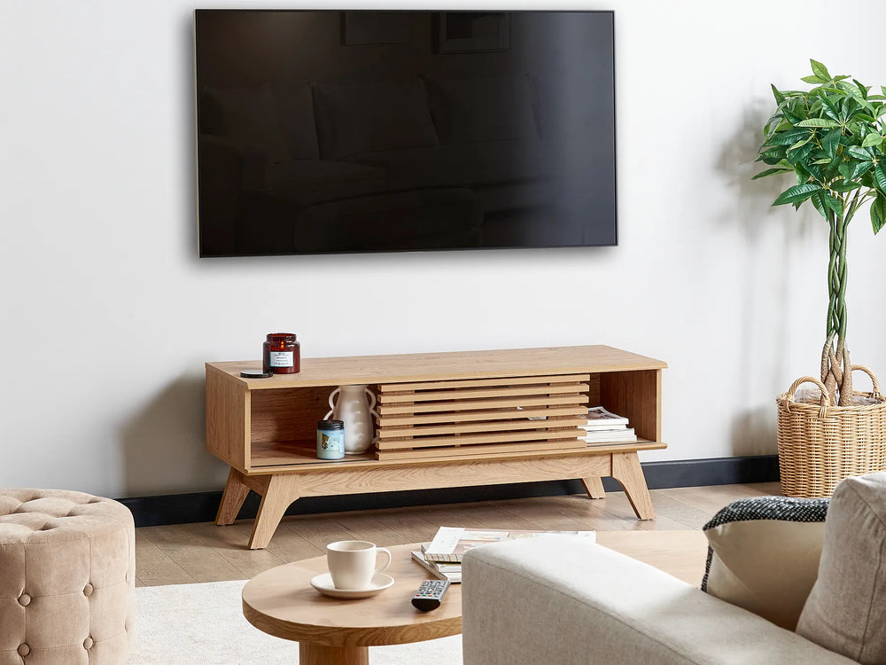 Modern living room with a wooden TV stand, sofa, and decorative items.