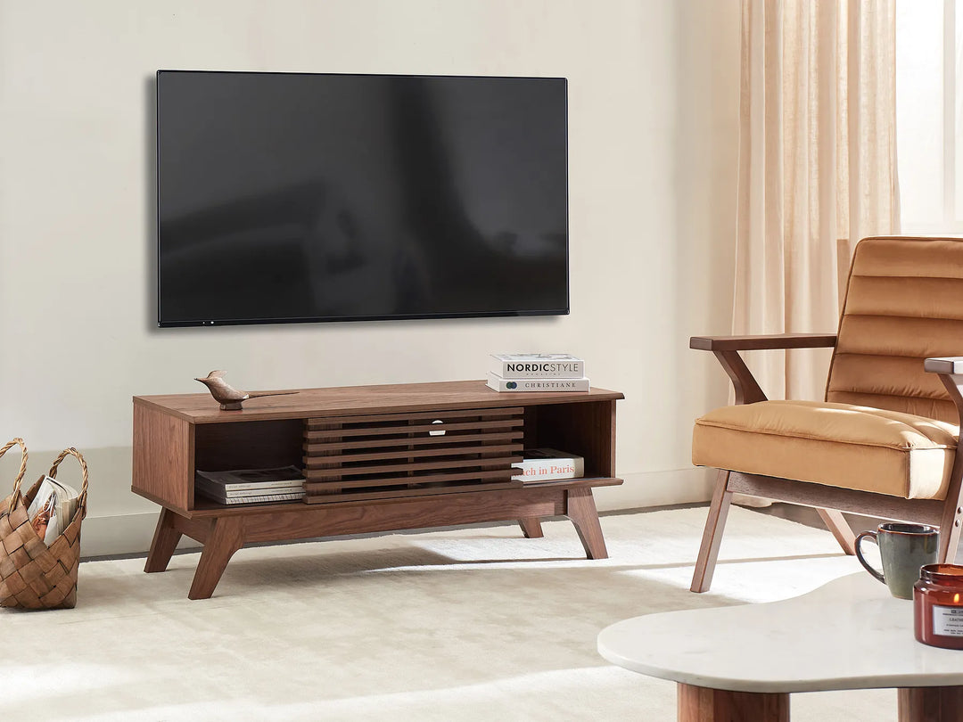 Modern living room with a wooden TV stand, leather armchair, and wall-mounted TV.