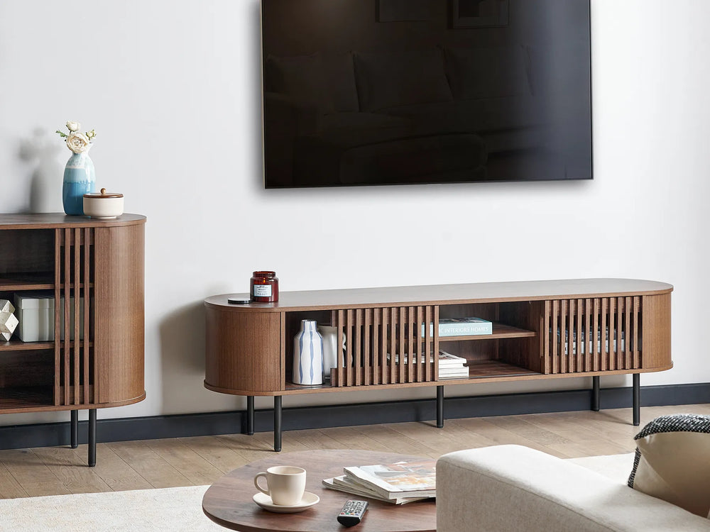 Modern living room with wooden TV stand, sofa, and wall-mounted TV.