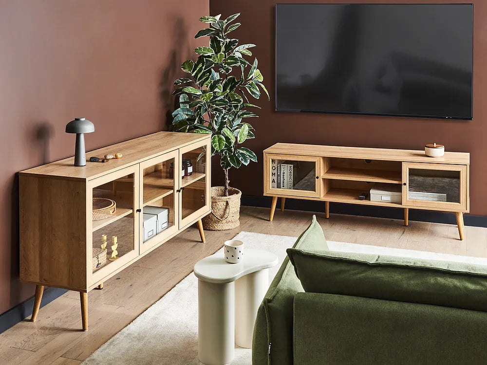 Modern living room with wooden TV stands, a green sofa, and a plant.