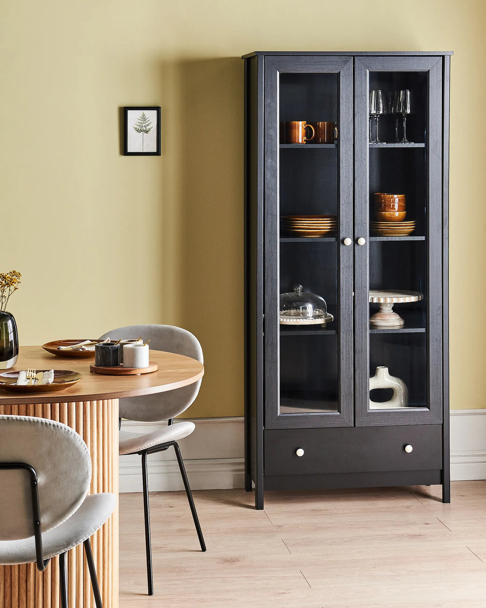 Dining room with a black glass-fronted cabinet and a wooden table.