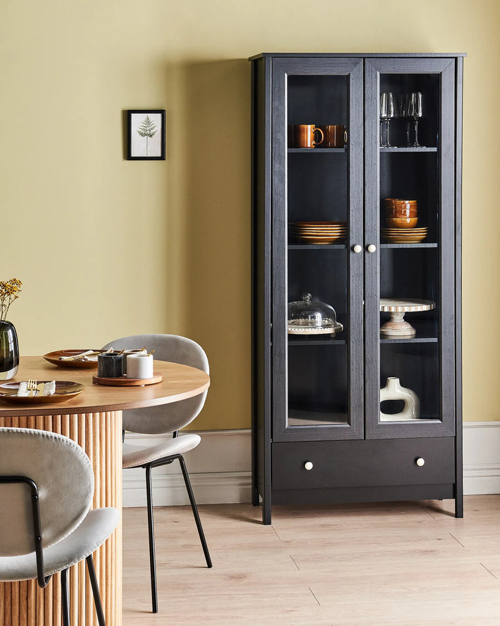 Dining room with a black glass-fronted cabinet and a wooden table.