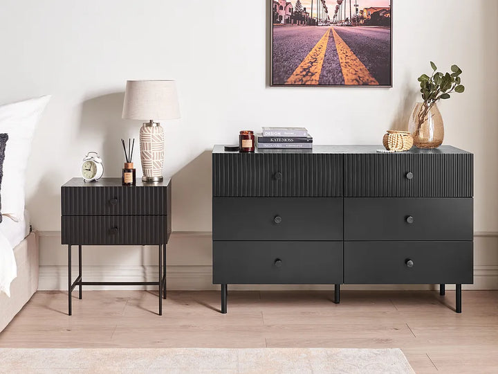 Black dresser with nightstand in a bedroom setting