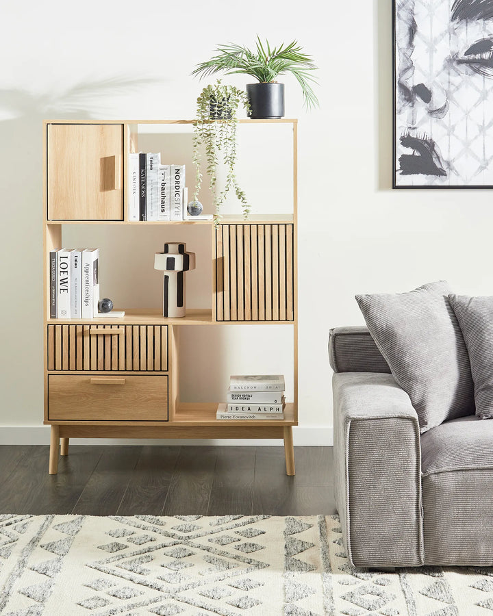 Wooden bookshelf with books and decor items in a living room setting.