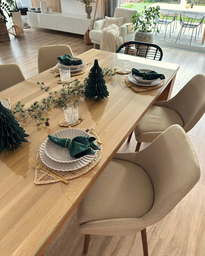 Dining table set with Christmas decorations in a modern living room.