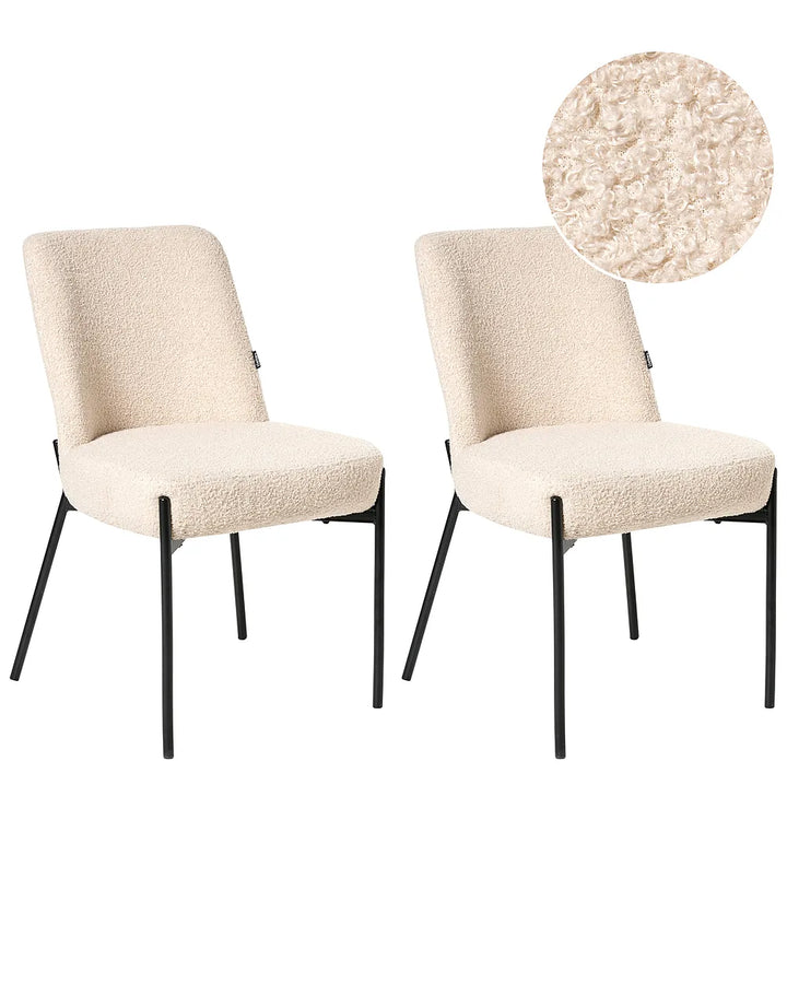 Two beige upholstered chairs with black legs on a white background