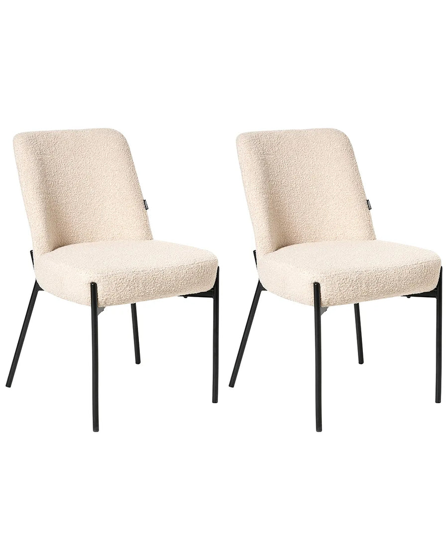 Two matching dining chairs with textured cream boucle upholstery and slim black metal legs, shown side by side on a plain white background.