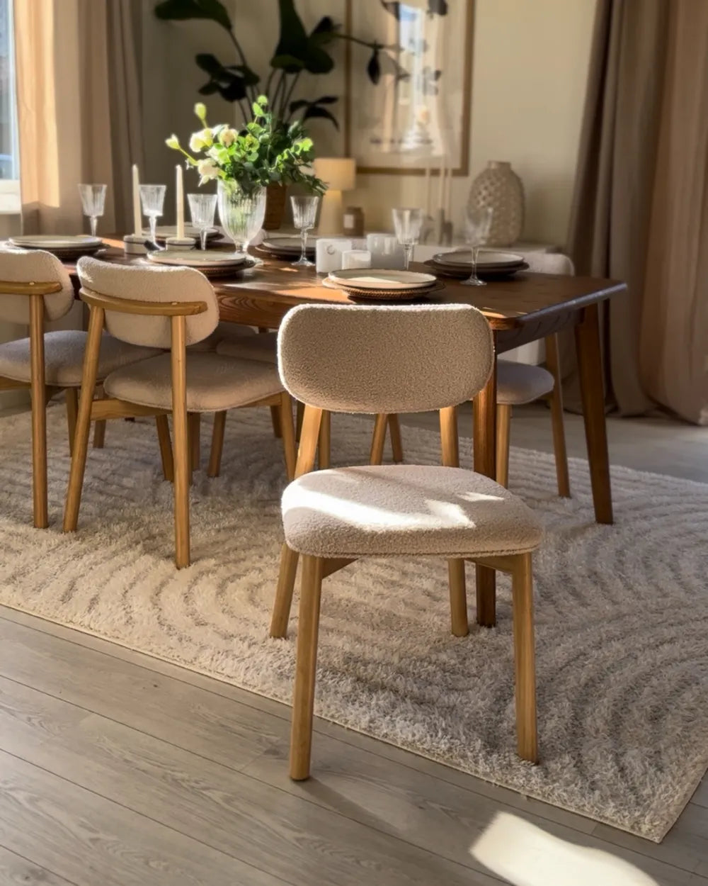 Pair of beige upholstered dining chairs with wooden frames