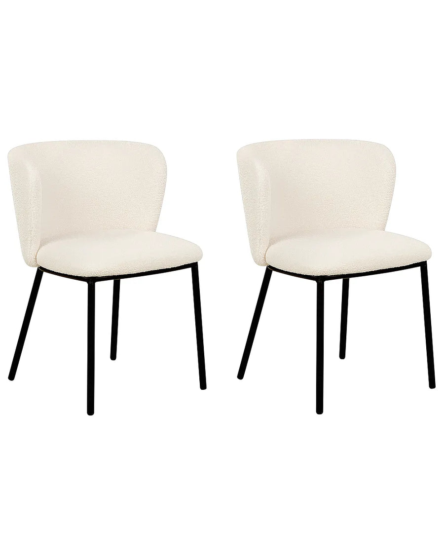 Two modern dining chairs with cream upholstered seats and curved backs, supported by slim black metal legs, shown against a plain white background.