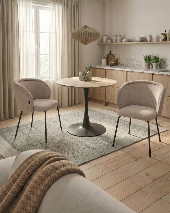 A modern upholstered accent chair with a curved backrest and seat, upholstered in a textured light beige fabric.