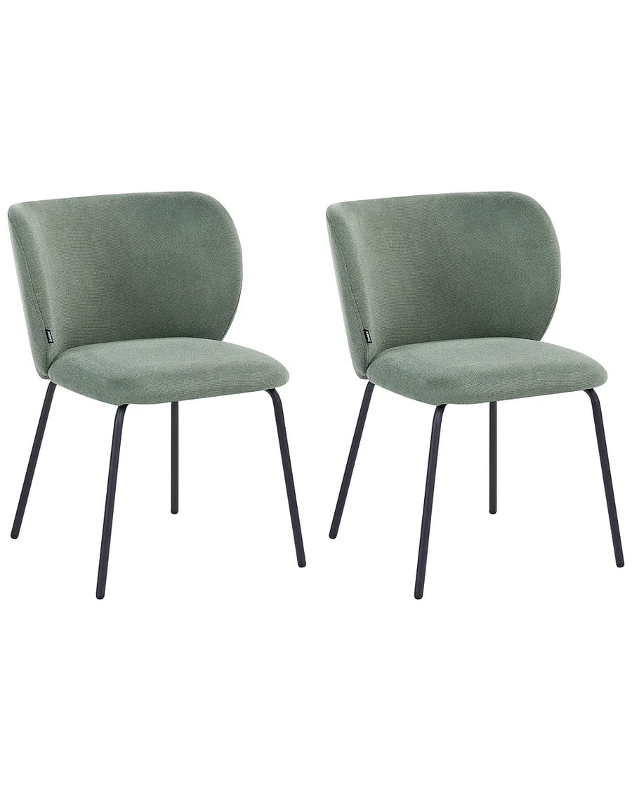 Two matching upholstered dining chairs in a muted sage green velvet fabric with slim black metal legs, shown side by side on a plain white background.