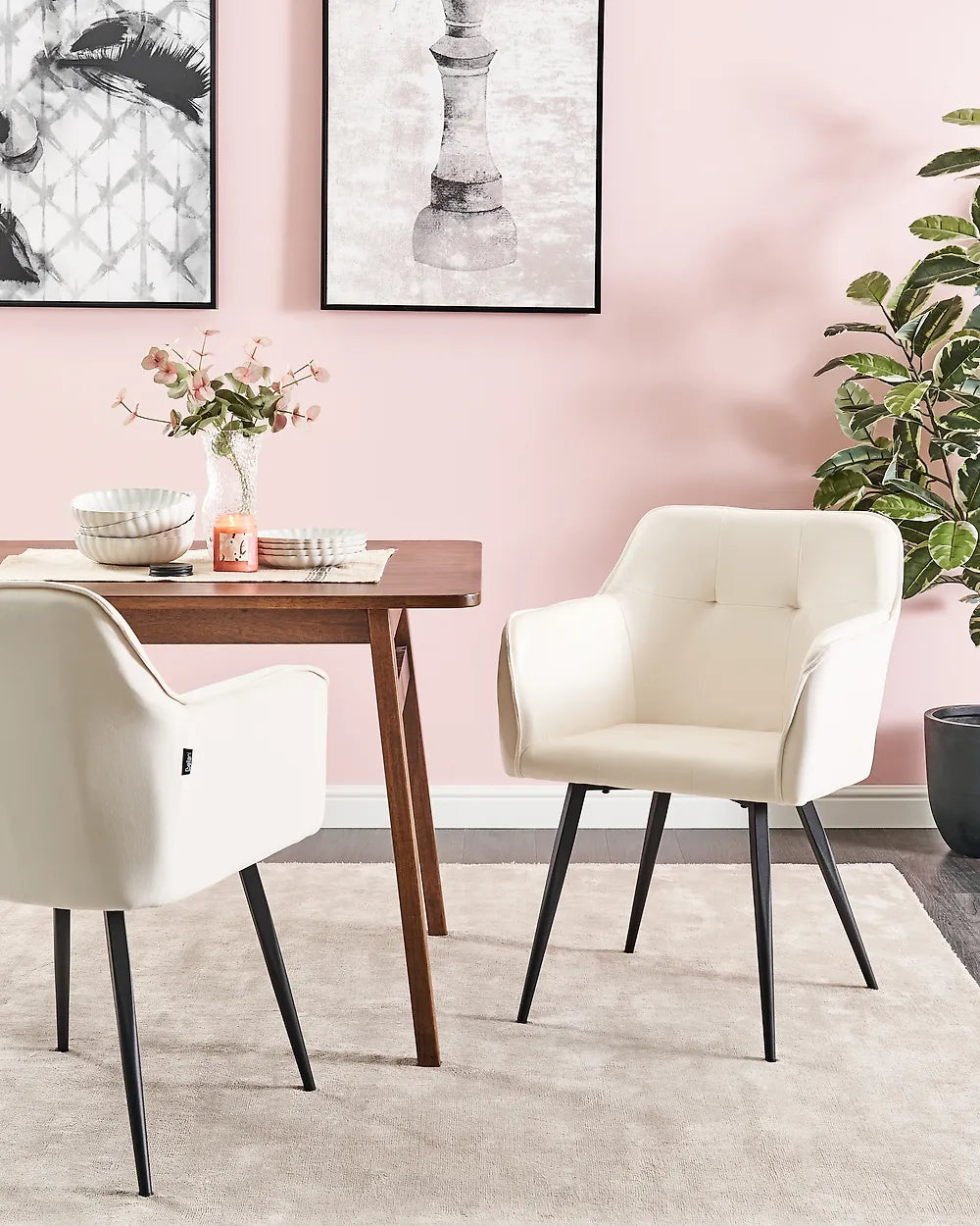 Dining area with white chairs, a wooden table, and pink walls.