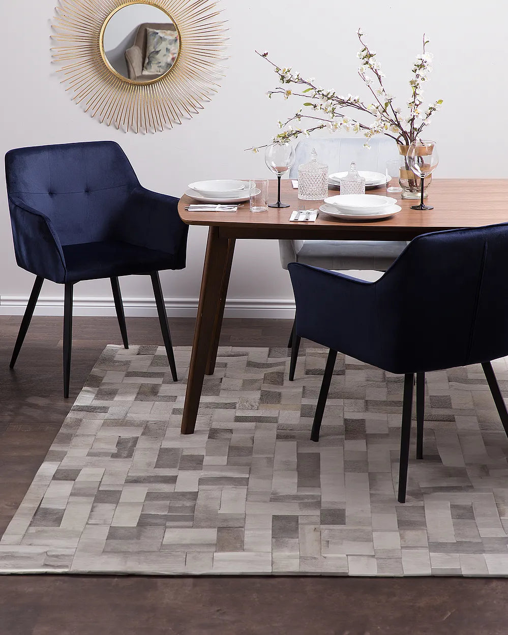 Dining room with a wooden table, navy chairs, and decorative elements.