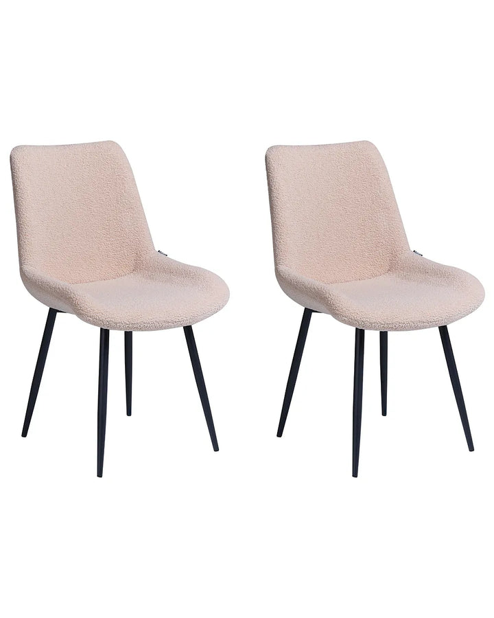 Two modern dining chairs with textured blush pink bouclé upholstery and slim black metal legs, shown side by side on a plain white background.