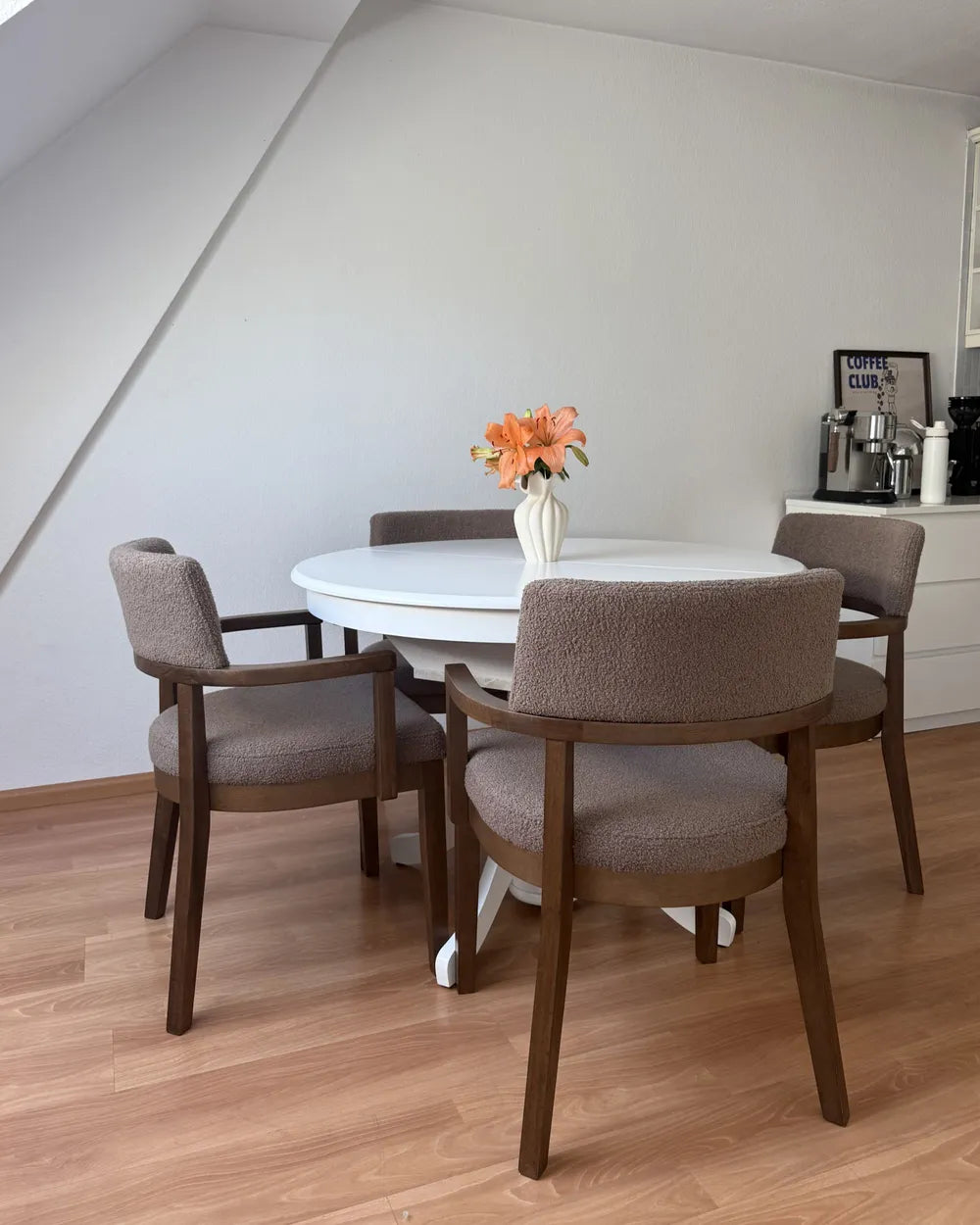 Two upholstered dining chairs with dark wood frames and textured beige fabric,