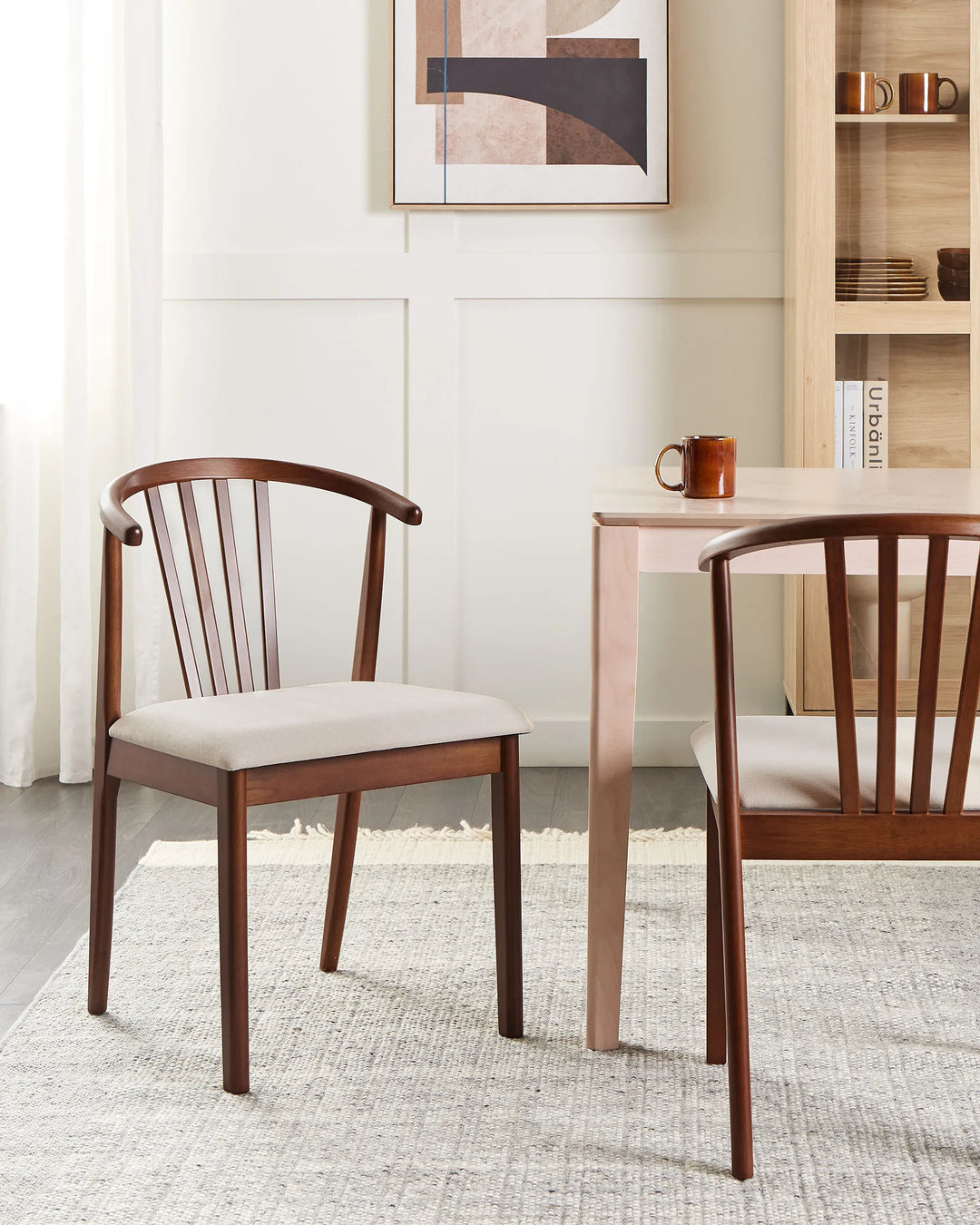 Dining room with wooden chairs and a table, featuring a abstract painting on the wall.