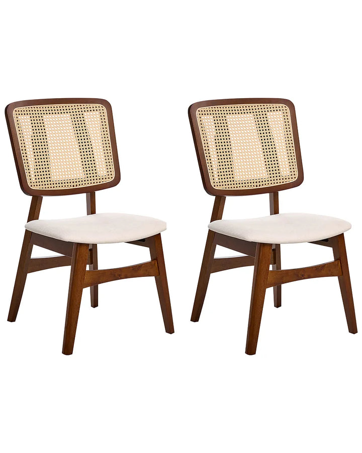 Two mid-century modern dining chairs with dark brown wooden frames, woven cane backrests, and cream upholstered seats, shown against a plain white background.
