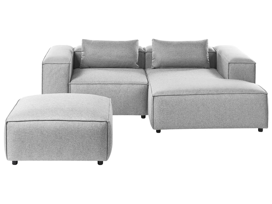 Gray sectional sofa with ottoman on a white background