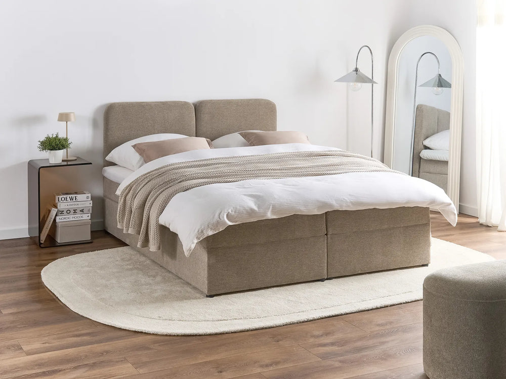 Beige upholstered bed with white bedding in a modern bedroom setting.