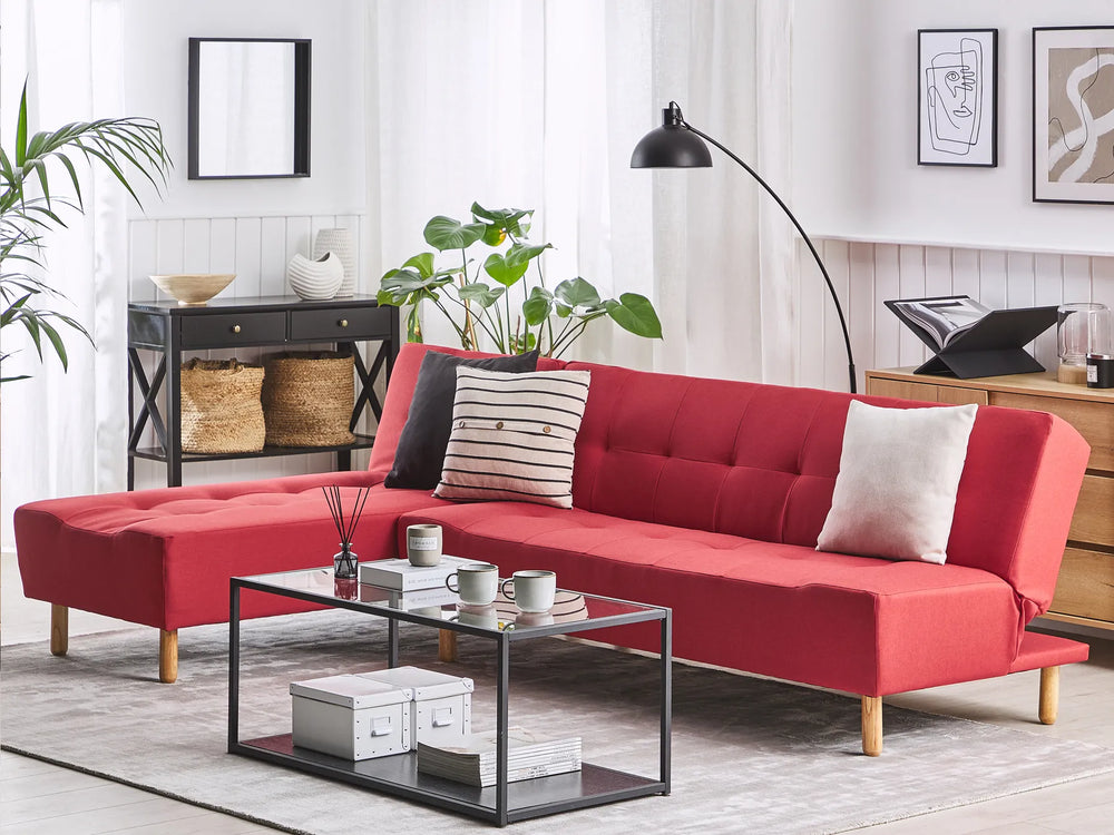 Red sectional sofa in a living room with a coffee table and decor items.