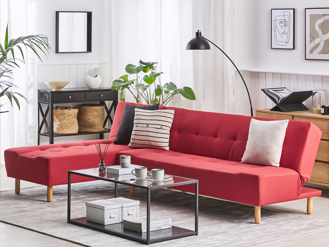 Red sectional sofa in a living room with a coffee table and decor items.