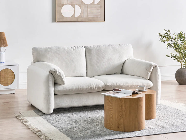 White sofa in a living room with a wooden coffee table and decorative items.