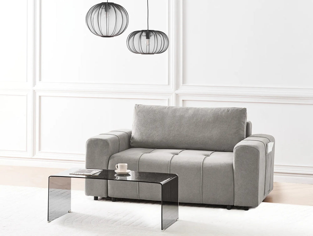 Gray sofa in a modern living room with a coffee table and decorative lamps.