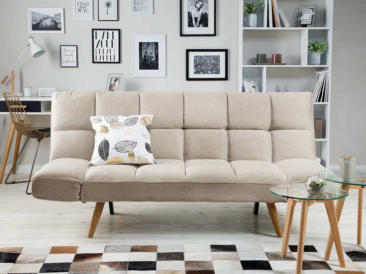 Beige sofa with a decorative pillow in a living room setting.