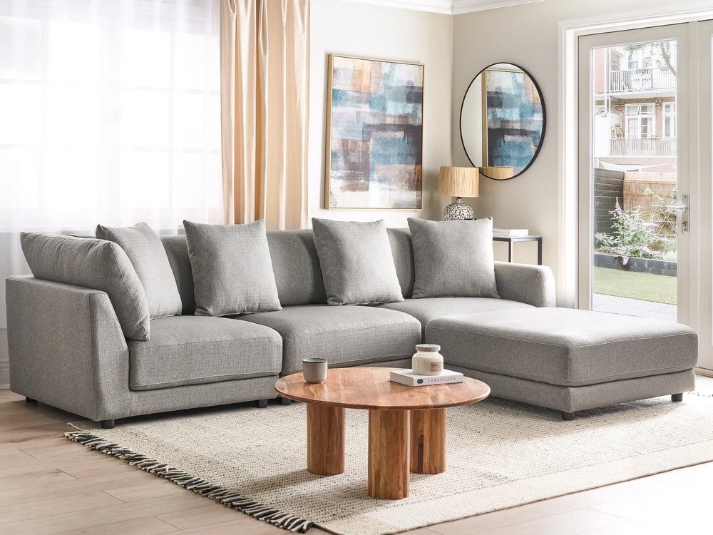 Gray sectional sofa in a living room with a wooden coffee table and decorative items.