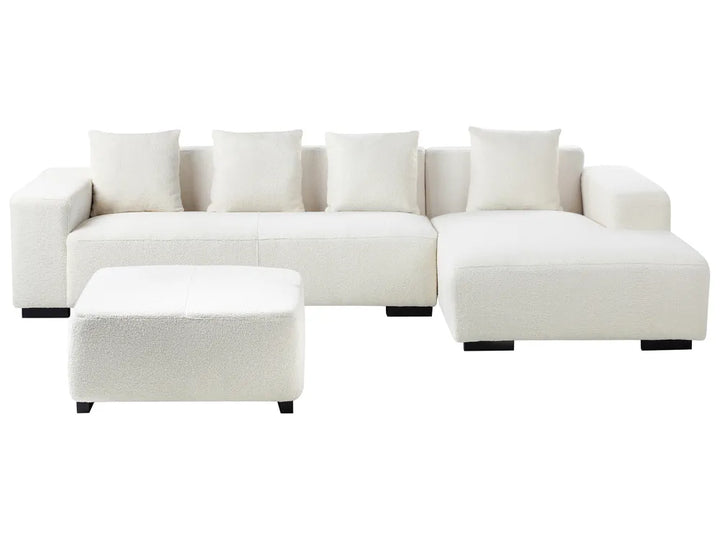 White sectional sofa with ottoman on a white background