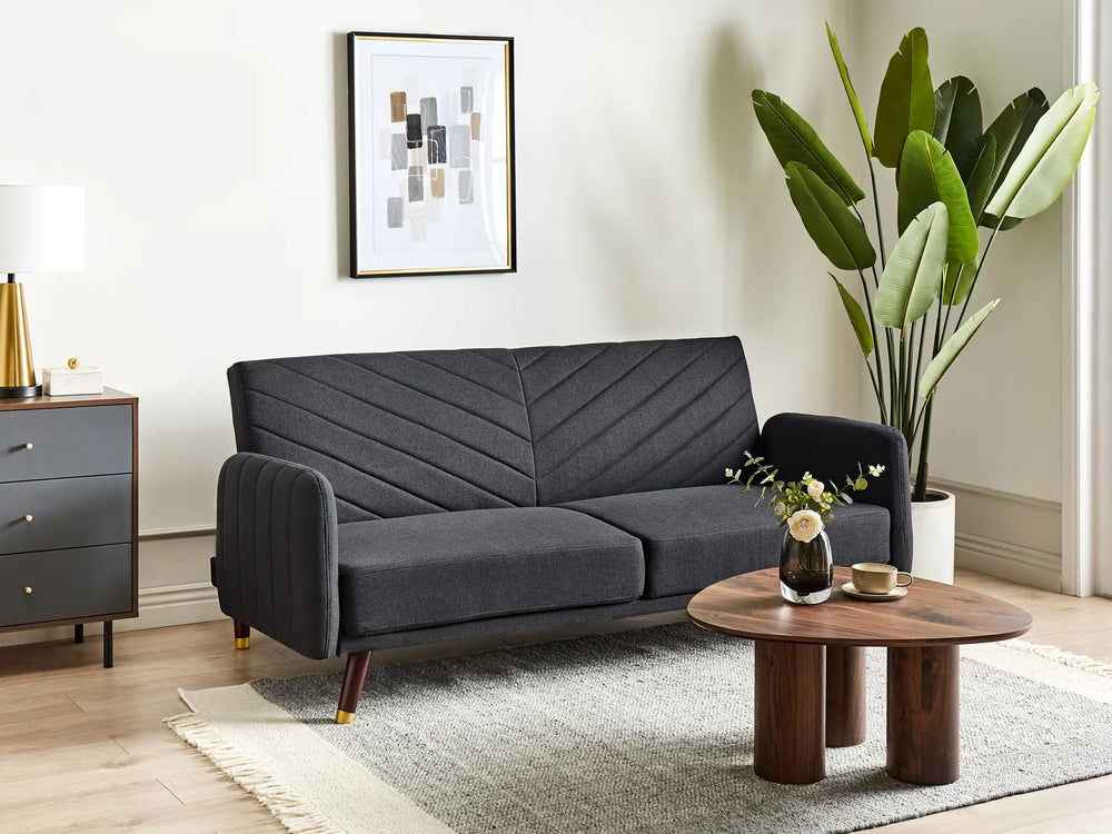 Gray sofa in a living room with a wooden coffee table and decorative items.