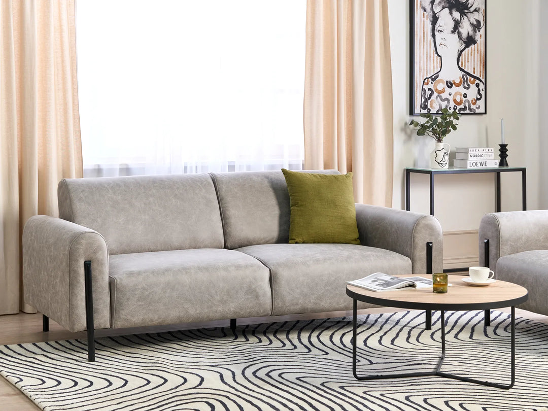 Gray sofa with a green pillow in a living room setting.