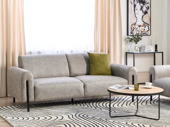 Gray sofa with a green pillow in a living room setting.