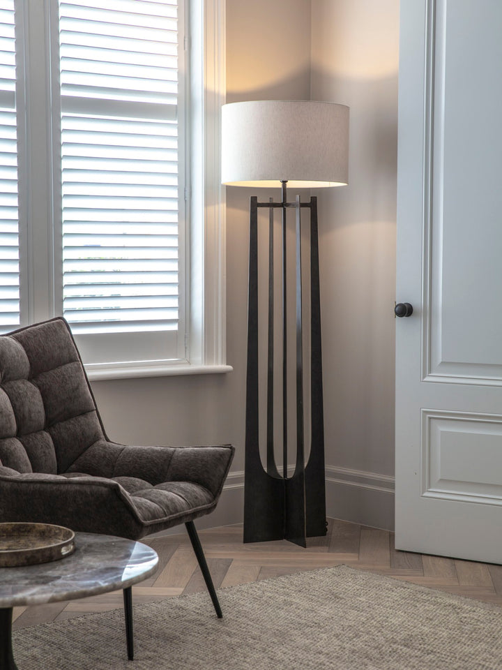 Modern living room with a gray armchair, round coffee table, and a tall floor lamp.