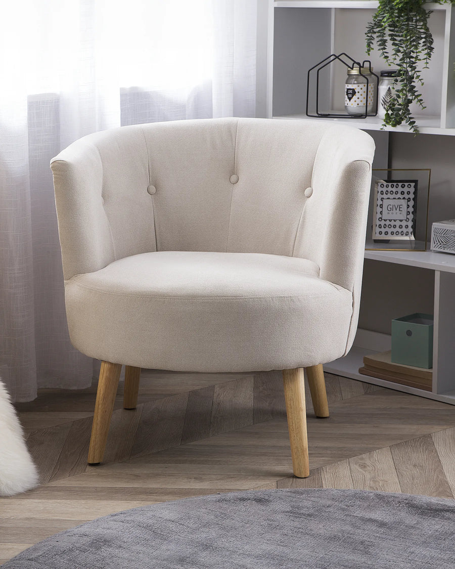 Beige armchair in a room with a shelf and decorative items.