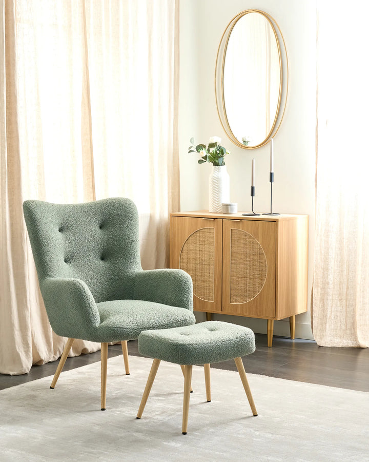 Green armchair and ottoman in a room with wooden cabinet and mirror