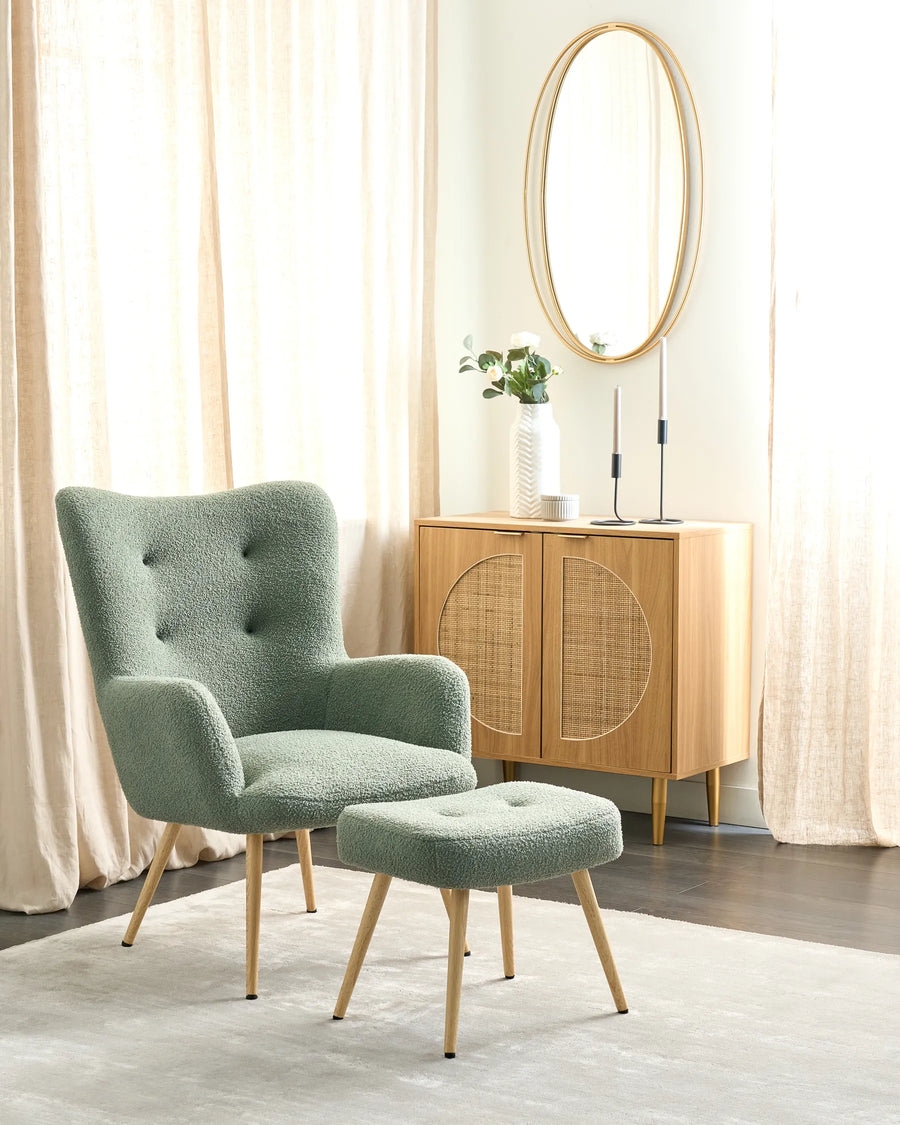 Green armchair and ottoman in a room with wooden cabinet and mirror