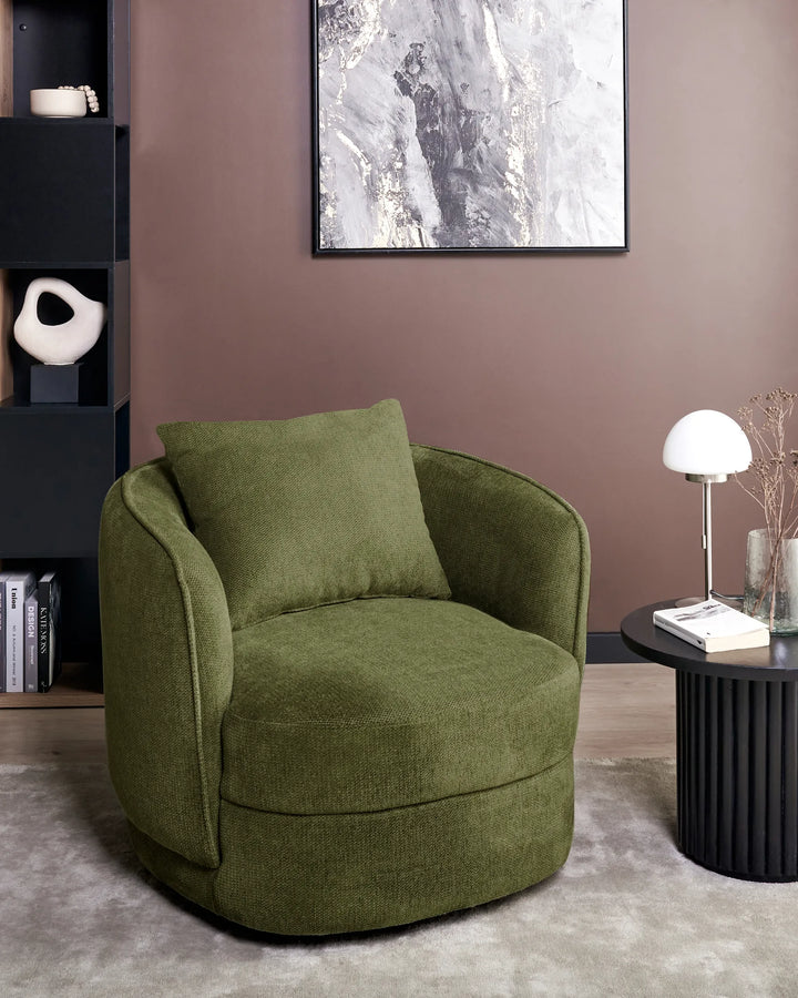 Green armchair in a modern living room with a bookshelf and abstract painting.