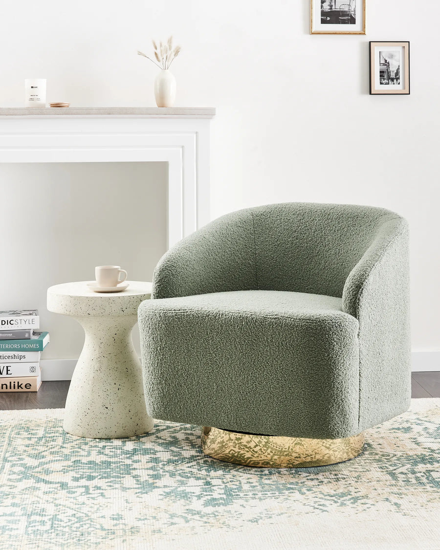 Green armchair in a living room with a side table and decor items.