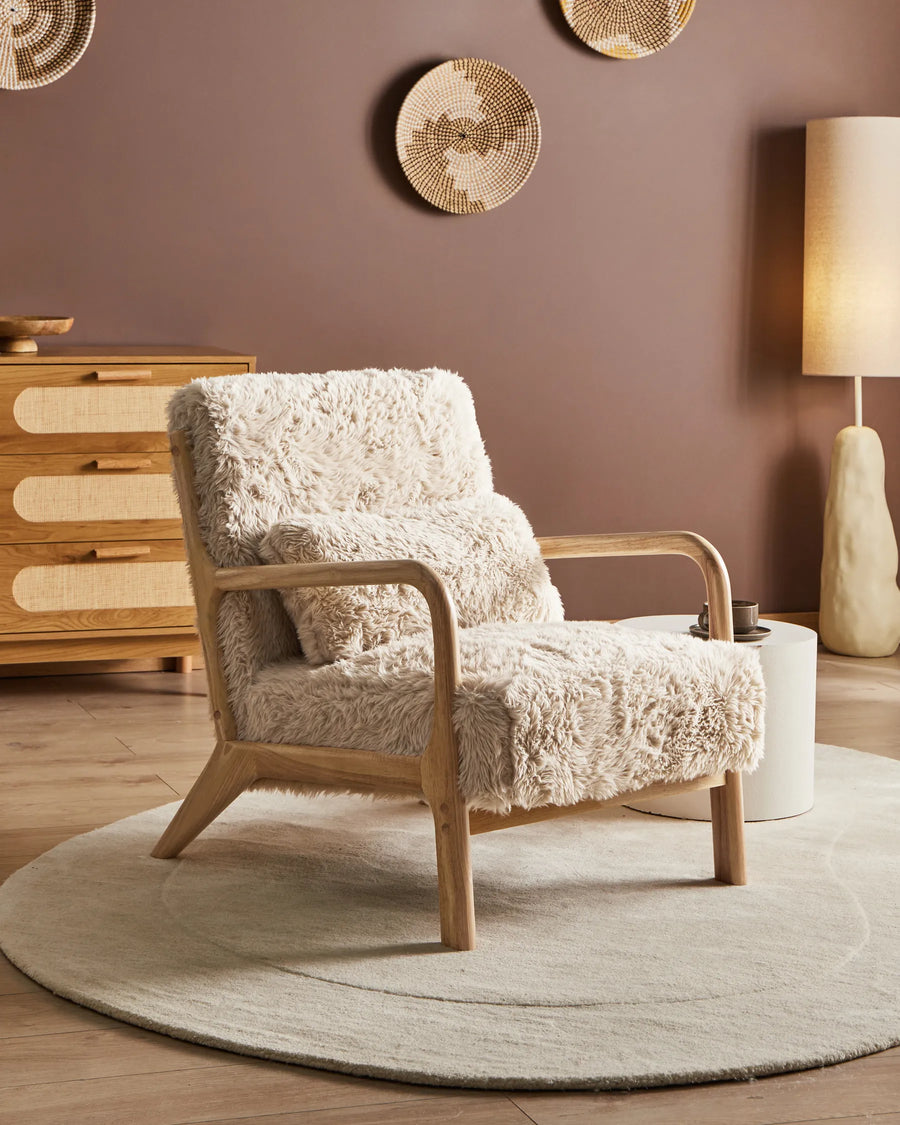 Wooden armchair with a textured beige cover in a room with a brown wall and decorative elements.