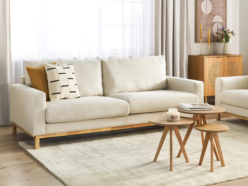 Beige sofa with wooden legs in a living room setting
