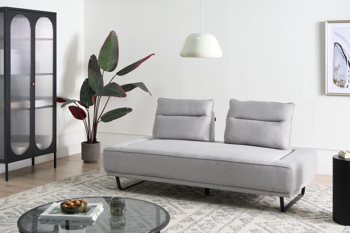 Modern living room with a gray sofa, round glass coffee table, and decorative items.